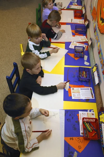 Muchos niños dibujando y divirtiéndose juntos en su clase de jardín de infantes — Foto de Stock