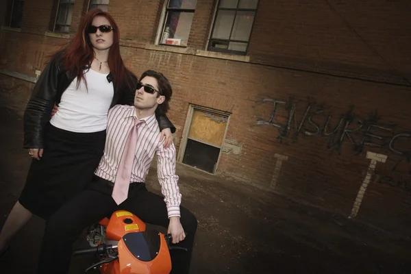 Trendy paar poseren op een scooter — Stockfoto