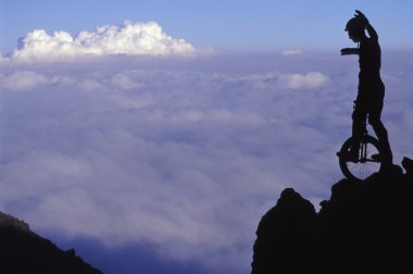 adam tek tekerlekli sirk bisikletine binme cliff üzerinde