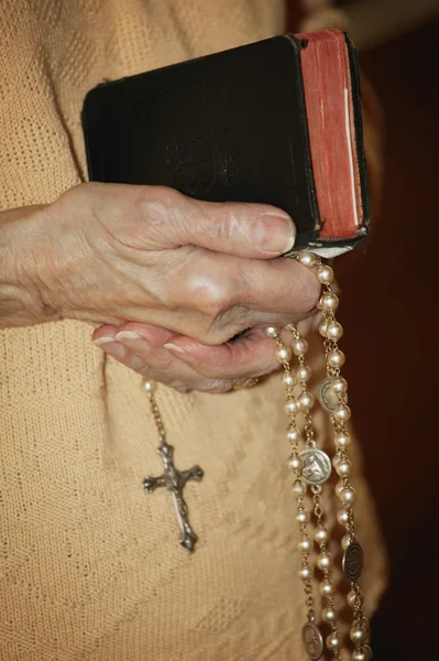 Abalorios de Rosario y la Biblia celebrada — Foto de Stock