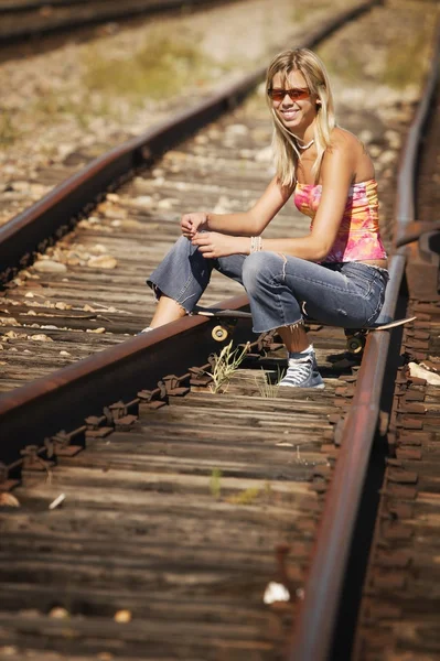 Mulher sentada em trilhas de trem — Fotografia de Stock