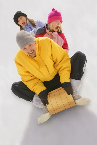 Vater und Töchter auf Schlitten — Stockfoto