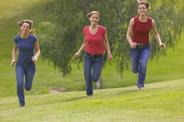 Três adolescentes meninas correndo no parque — Fotografia de Stock