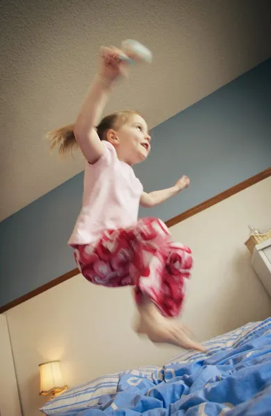 Springen op het bed — Stockfoto