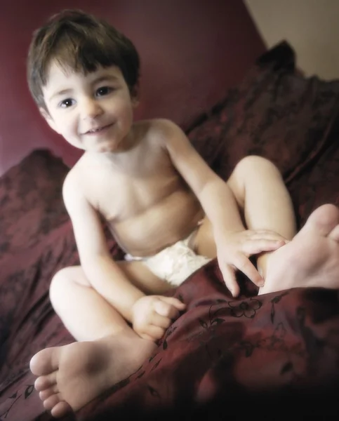 Niño sentado en la cama — Foto de Stock