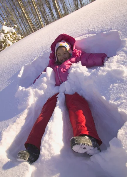 Mädchen macht einen Schnee-Engel — Stockfoto