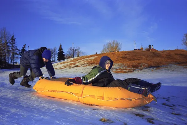 Zwei Jungen schieben ein Floß einen Hügel hinunter — Stockfoto