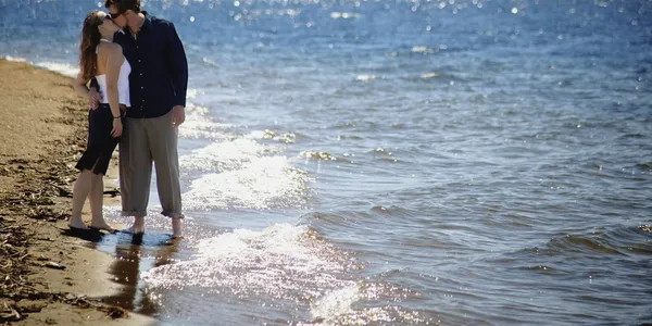 Par kyssar på stranden — Stockfoto