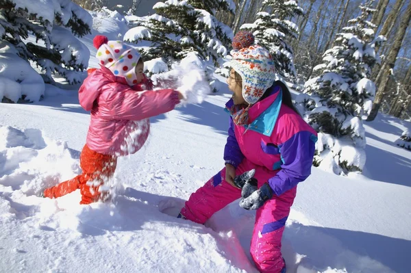 Mère et fille ayant une bataille de boule de neige — Photo