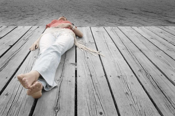 Vrouw liggen op dok — Stockfoto