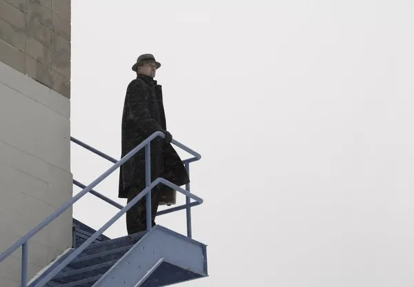 Uomo solitario in piedi su una scala esterna — Foto Stock