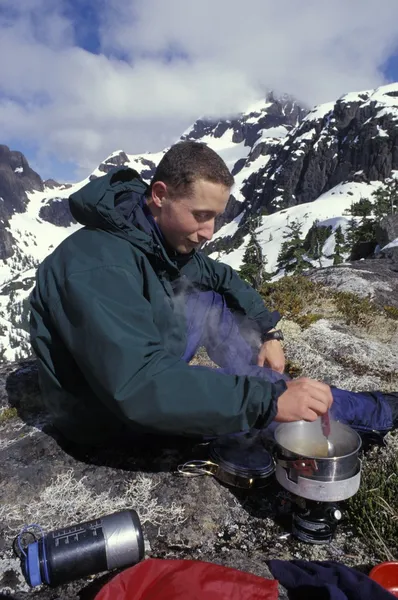 Montañista usando una estufa de camping — Foto de Stock