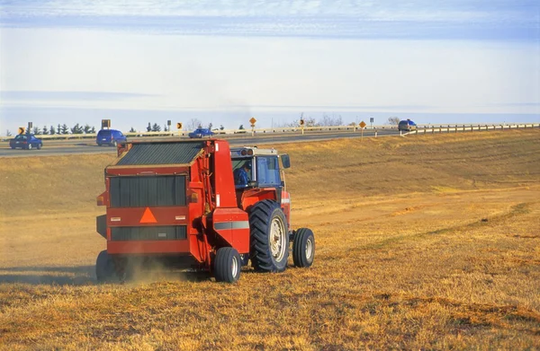 Traktorn arbetar bredvid motorväg — Stockfoto