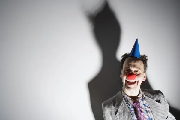 Hombre con la nariz y el sombrero de un payaso — Foto de Stock