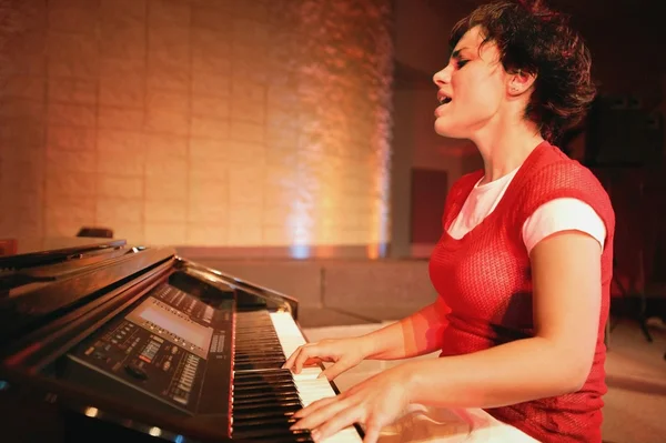 Mulher toca piano e canta — Fotografia de Stock