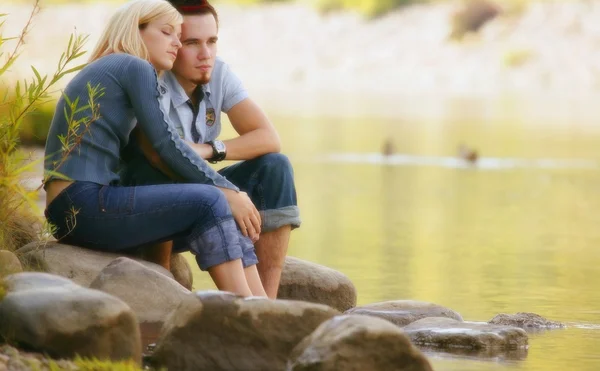 Pareja sentada cerca del agua — Foto de Stock