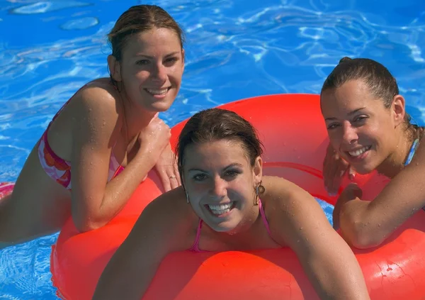 Retrato de tres mujeres jóvenes en la piscina — Foto de Stock