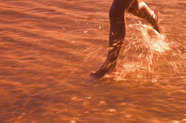 Enfant traversant l'eau sur la plage — Photo