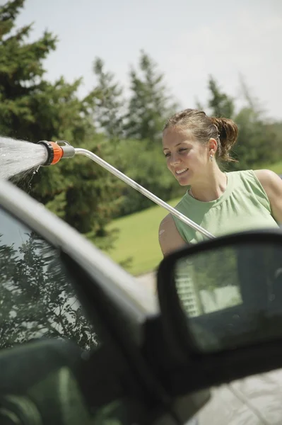 Kadın arabayı yıkıyor. — Stok fotoğraf