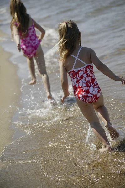 Zwei Kinder laufen am Strand entlang — Stockfoto
