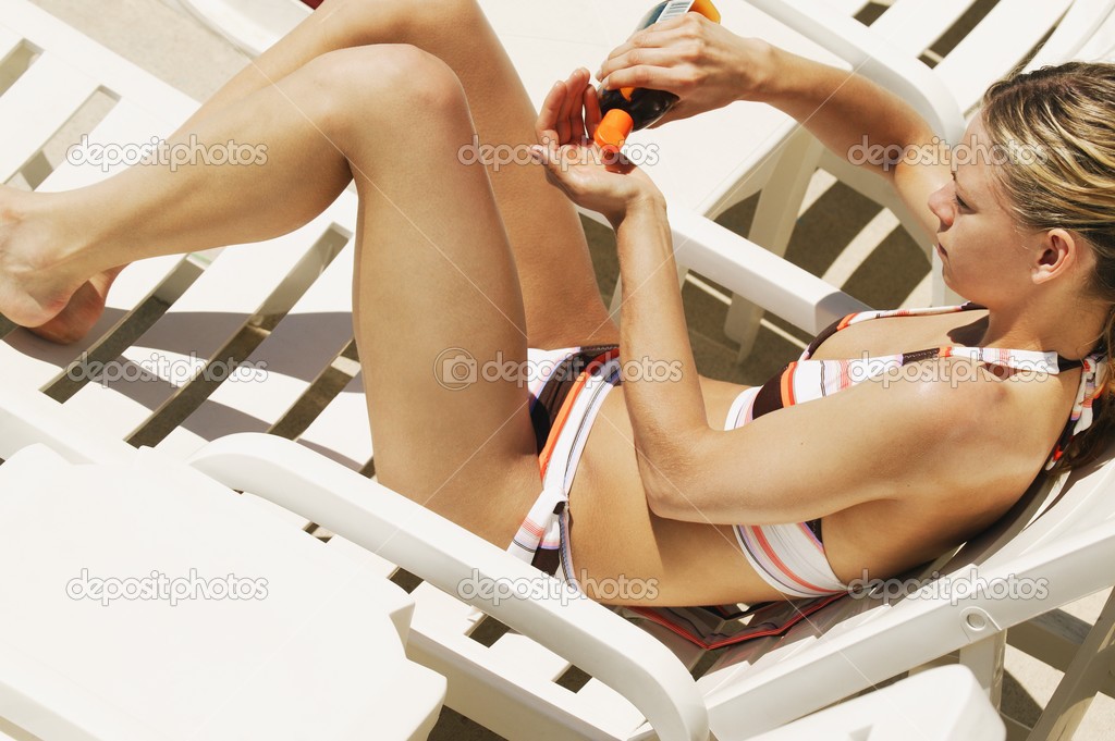 Woman Applies Suntan Lotion