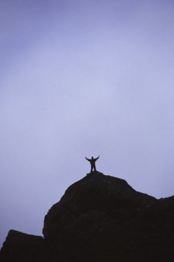 Lone Hiker On Top Of Mountain Peak clipart