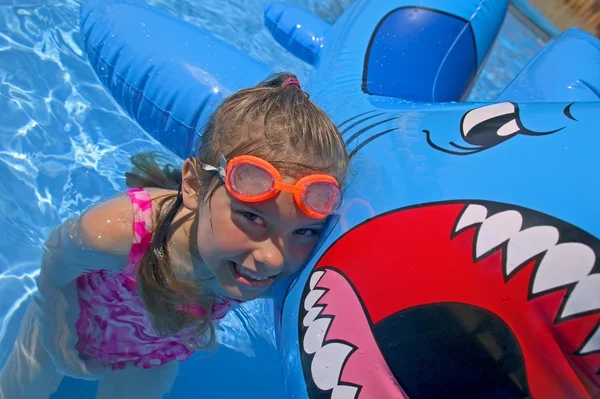 Meisje spelen in zwembad met opblaasbare haai — Stockfoto