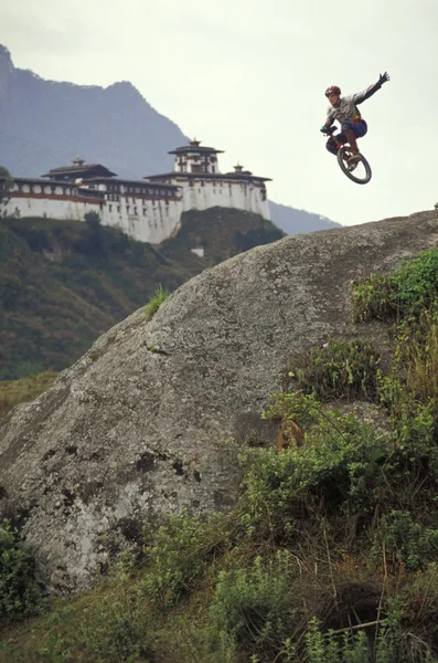 Unicyclist tomando un salto abajo de una colina —  Fotos de Stock