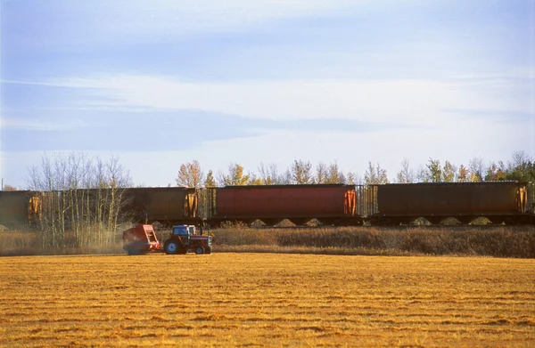 Tracteur à côté d'un train — Photo