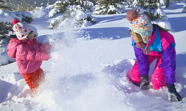 Mãe e filha tendo uma luta de bola de neve — Fotografia de Stock