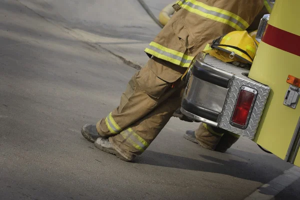 Feuerwehrmann lehnt an Feuerwehrauto — Stockfoto