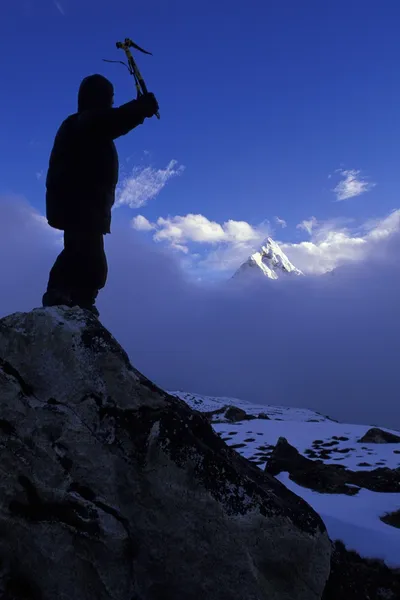 En yüksek dağ tepe yükselen bulutlar arka planda dışarı ile dağcı — Stok fotoğraf