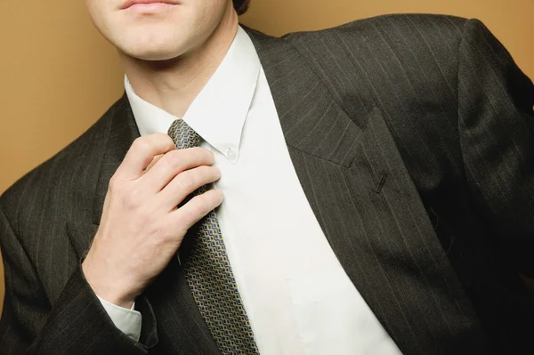 Un hombre de negocios ajusta la corbata — Foto de Stock