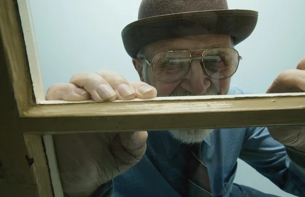 Homem olha pela janela — Fotografia de Stock