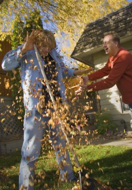 Father Throws Leaves At Son clipart