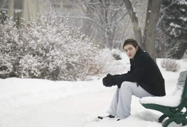 雪に覆われたベンチに座っています。 — ストック写真