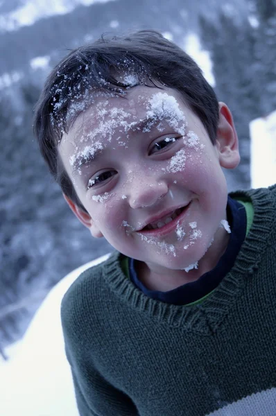 Menino com neve no rosto — Fotografia de Stock