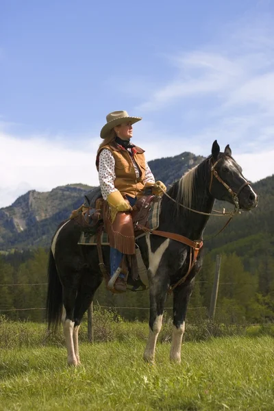 Eine Frau auf einem Pferd gegen die Berge — Stockfoto