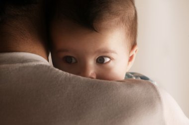 Babalar omuz üzerinden bakan bebek