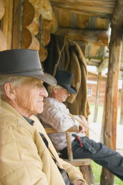 Two Men Relaxing On Veranda