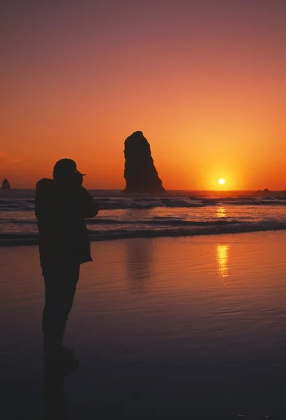 Silhouette Di Persona Visualizzazione Tramonto, Formazione rocciosa, Cannon Beach . — Foto Stock