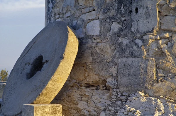 Uma pedra de moinho encostada a uma parede de moinho de vento — Fotografia de Stock