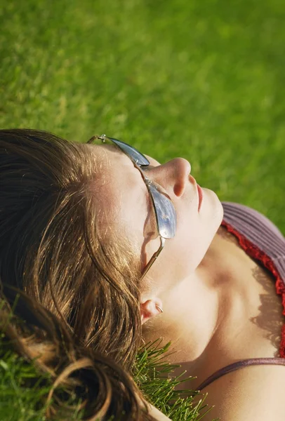 草の上 sunbathes, 若い女性 — ストック写真