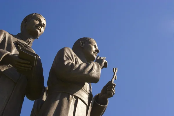 Statue zweier Männer mit Kreuz und Buch — Stockfoto
