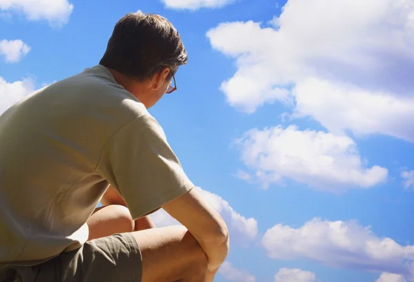 En man tittar på en molnig himmel — Stockfoto