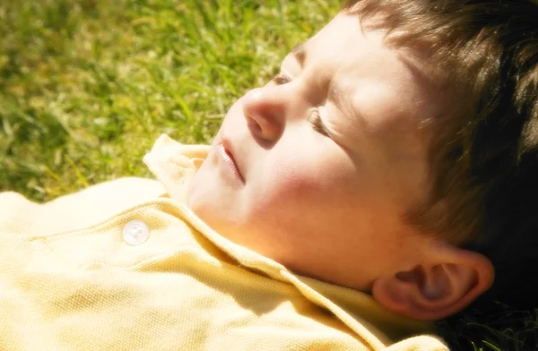 Un giovane ragazzo sdraiato al sole — Foto Stock