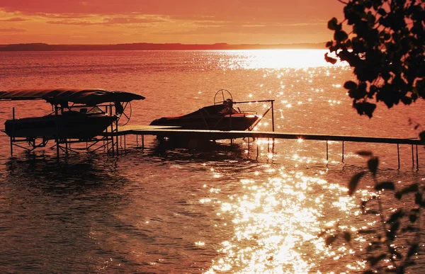 Tramonto sul lago e silhouette di barche — Foto Stock