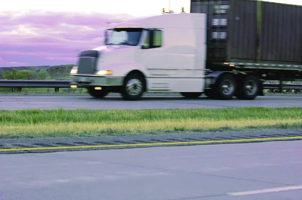 Een semi-vrachtwagen op een snelweg — Stockfoto