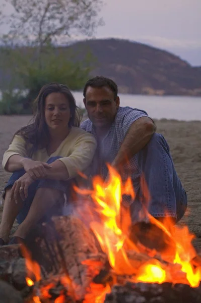 Casal sentado pelo fogo — Fotografia de Stock