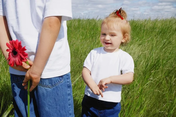 少年は彼の背中の後ろに花を保持します。 — ストック写真